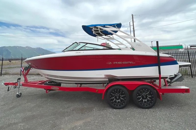 Slide: The Image of 2022 Regal LS2 Surf boat on a red trailer, side view. - 6