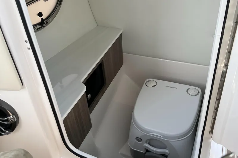 Slide: The Image of 2022 Regal LS6 Surf boat interior bathroom with toilet and storage. - 5