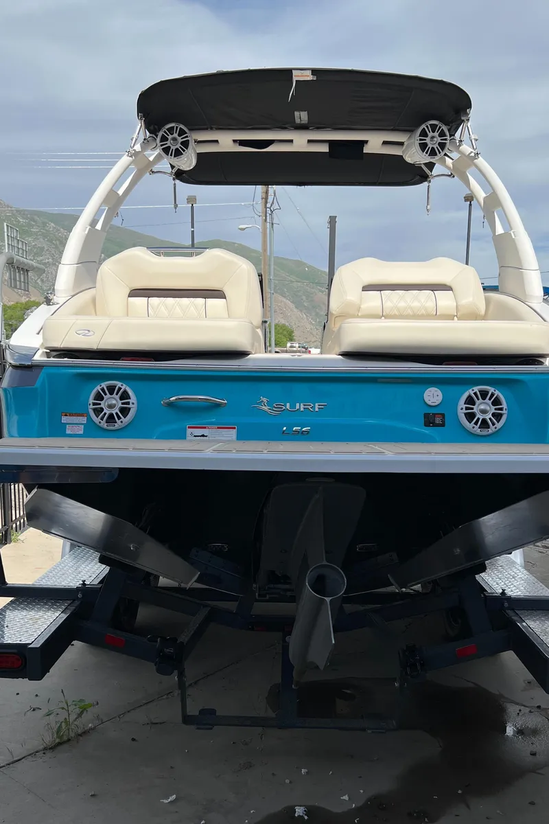 Slide: The Image of 2022 Regal LS6 Surf boat with blue exterior and twin seats. - 6
