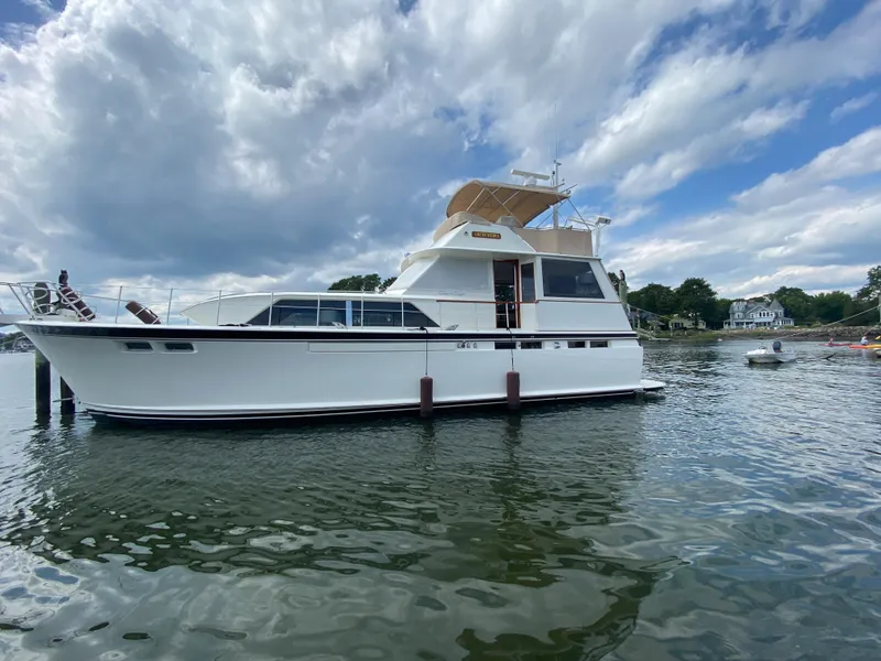 Slide: The Image of 1973 Chris-Craft 47 Commander Flush Deck yacht on calm water under a cloudy sky. - 10