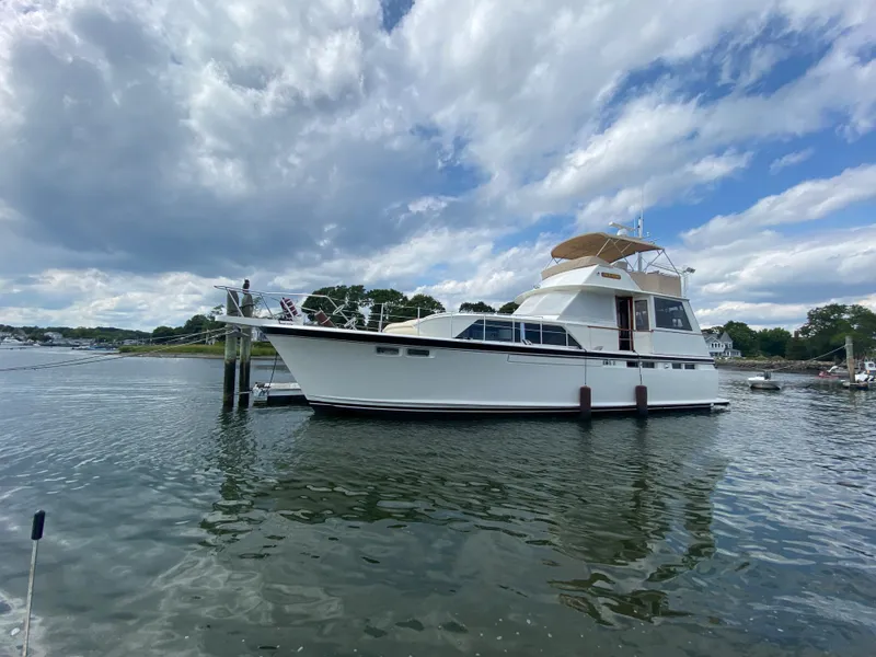 Slide: The Image of 1973 Chris-Craft 47 Commander Flush Deck yacht docked on a calm waterway. - 11