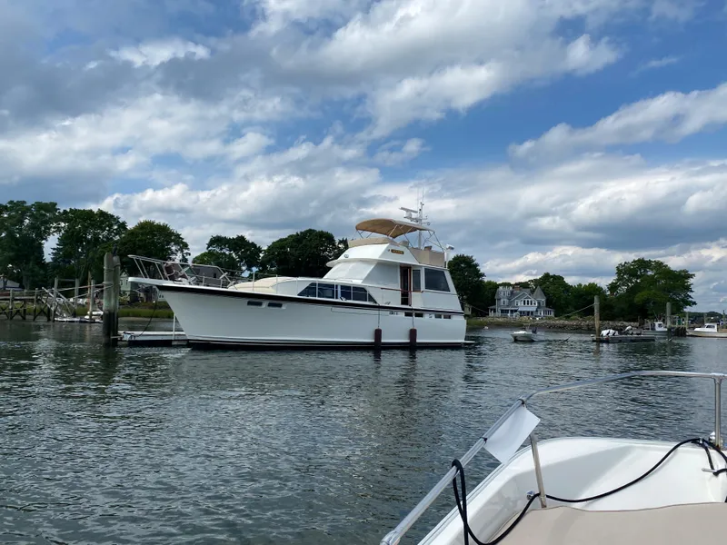 Slide: The Image of 1973 Chris-Craft 47 Commander Flush Deck yacht docked in a serene marina. - 12