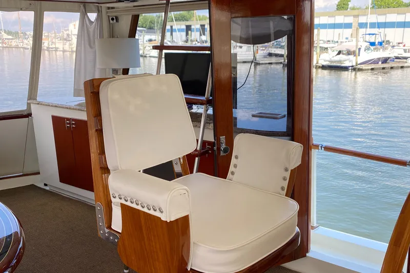 Slide: The Image of 1973 Chris-Craft 47 Commander Flush Deck interior with white captain's chair and marina view. - 14