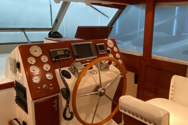 Slide: The Image of 1973 Chris-Craft 47 Commander Flush Deck helm with wooden steering wheel and navigation instruments. - 17