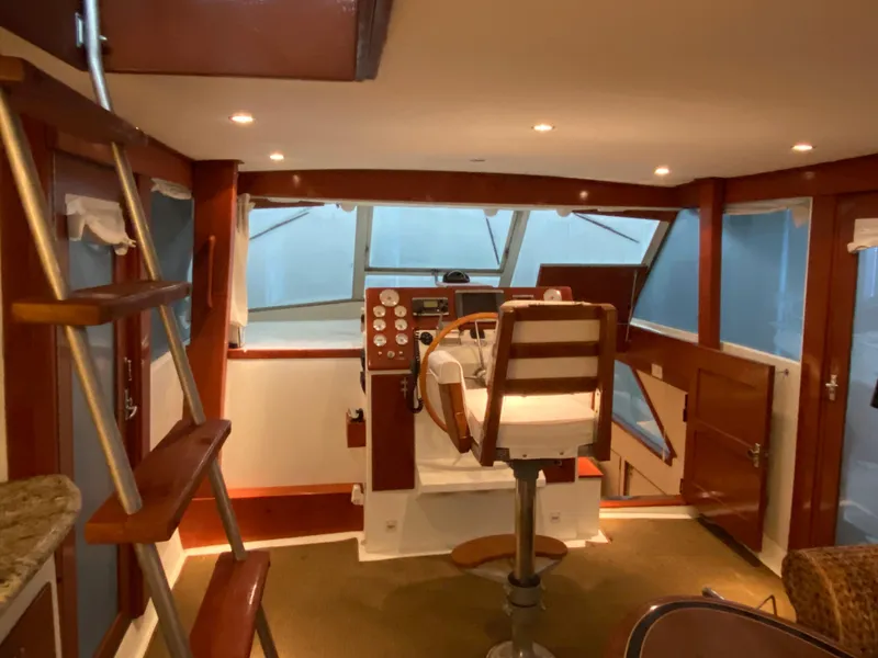 Slide: The Image of 1973 Chris-Craft 47 Commander Flush Deck helm station with wooden accents and ladder. - 19