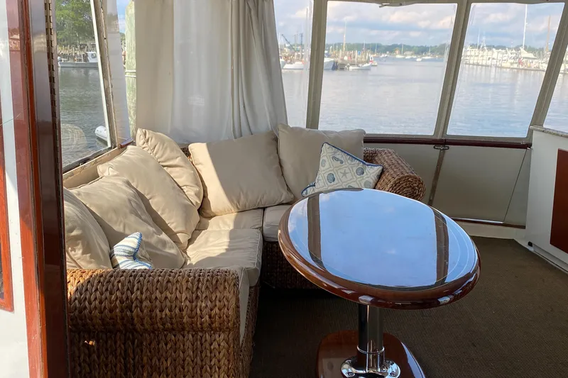Slide: The Image of 1973 Chris-Craft 47 Commander Flush Deck interior with wicker furniture and water view. - 26
