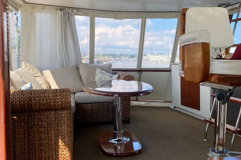 Slide: The Image of Interior of 1973 Chris-Craft 47 Commander Flush Deck yacht with wicker furniture and scenic windows. - 28