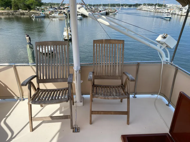 Slide: The Image of Two wooden chairs on the deck of a 1973 Chris-Craft 47 Commander Flush Deck yacht. - 31