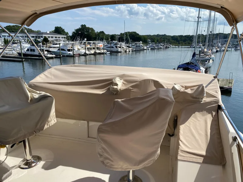 Slide: The Image of 1973 Chris-Craft 47 Commander Flush Deck at marina, covered helm and seats, scenic waterfront view. - 33