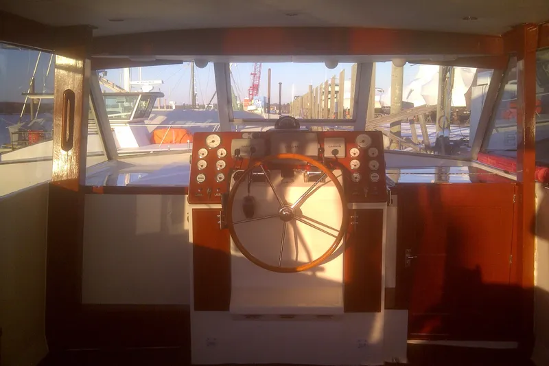 Slide: The Image of 1973 Chris-Craft 47 Commander Flush Deck helm with wooden steering wheel and instrument panel. - 47