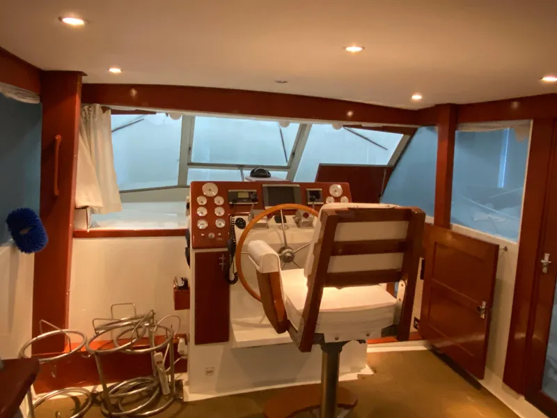 Slide: The Image of 1973 Chris-Craft 47 Commander Flush Deck helm station with wooden steering wheel and captain's chair. - 48