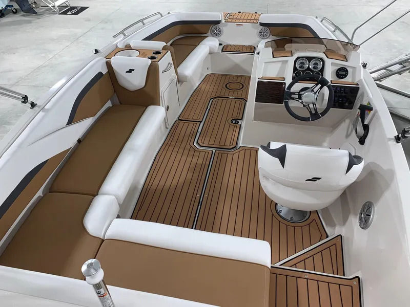 Slide: The Image of 2024 Starcraft SVX 191 boat interior with tan and white seating, modern dashboard, and wood-like flooring. - 3