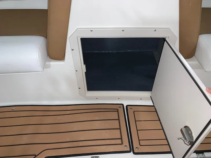 Slide: The Image of 2024 Starcraft SVX 191 boat interior storage compartment with open door and cushioned seating. - 7