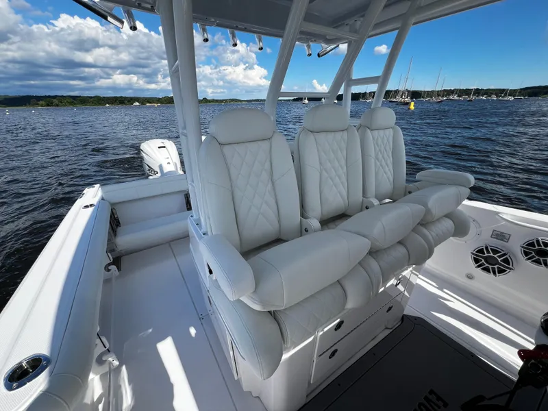 Slide: The Image of 2023 Everglades 335 Center Console boat with luxurious white seating on the water. - 11