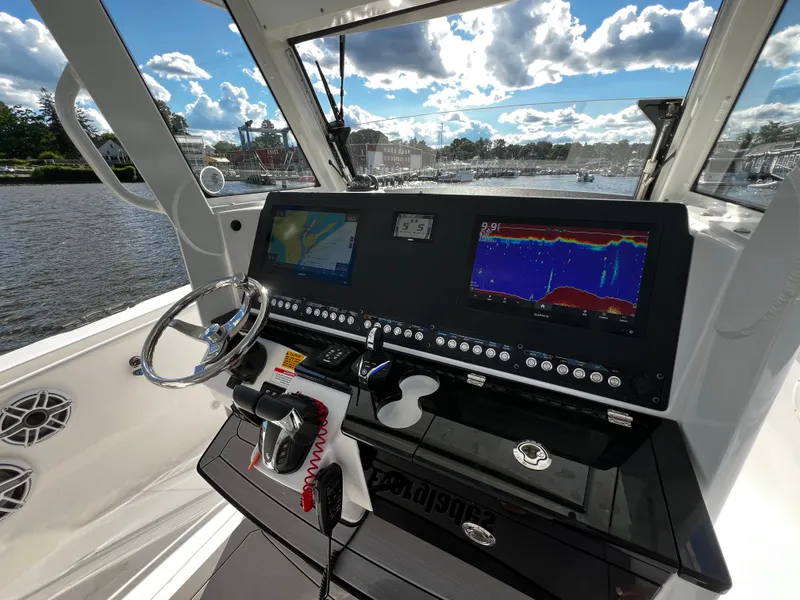 Slide: The Image of 2023 Everglades 335 Center Console boat dashboard with navigation and fish-finding screens. - 13