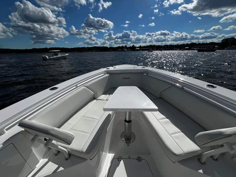 Slide: The Image of 2023 Everglades 335 Center Console boat with spacious seating and table on a sunny day. - 17