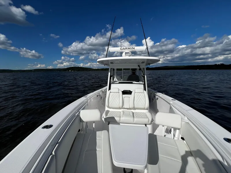 Slide: The Image of 2023 Everglades 335 Center Console boat on open water under blue sky. - 19