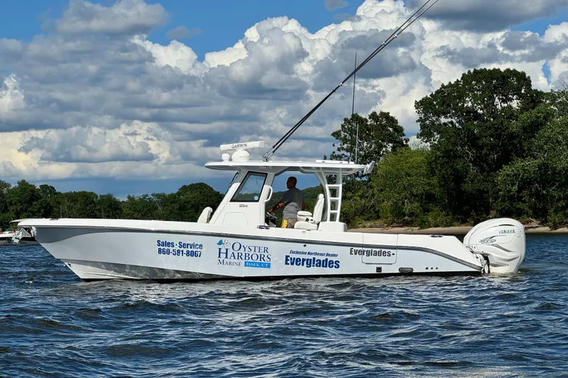 Slide: The Image of 2023 Everglades 335 Center Console boat cruising on a lake with trees in the background. - 4