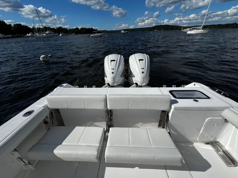 Slide: The Image of 2023 Everglades 335 Center Console boat with twin engines on a scenic lake. - 8