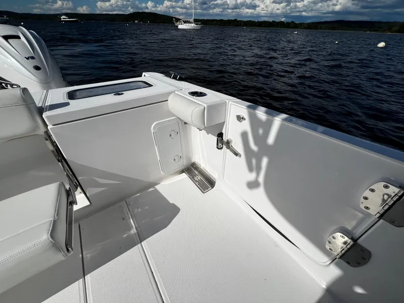 Slide: The Image of 2023 Everglades 335 Center Console boat interior, white deck, and seating, on a lake. - 9