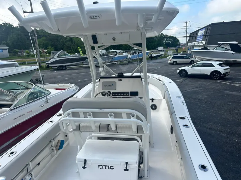 Slide: The Image of 2022 Sea Fox 248 Commander boat interior with seating and console, parked in a dealership lot. - 16