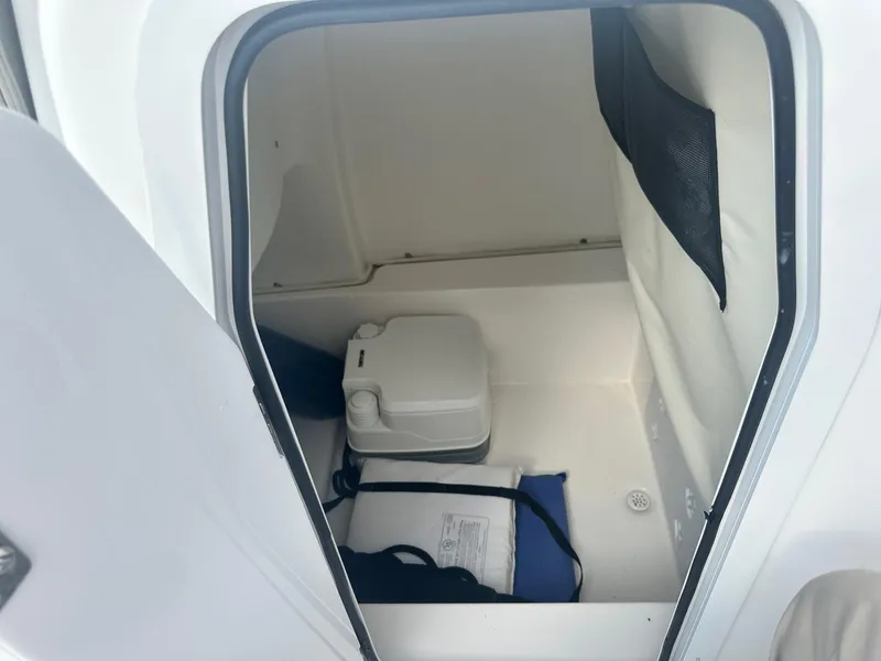 Slide: The Image of 2022 Sea Fox 248 Commander boat interior with storage compartment and portable toilet. - 24