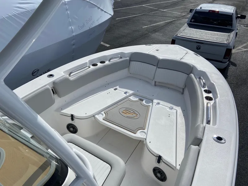 Slide: The Image of 2022 Sea Fox 248 Commander boat interior with seating and storage, parked near a truck. - 29