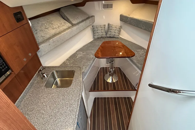 Slide: The Image of 2024 Albemarle 30 Express cabin interior with kitchenette, sink, and cozy seating area. - 12