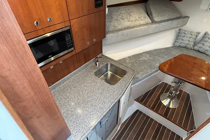 Slide: The Image of 2024 Albemarle 30 Express interior with kitchenette, sink, and cozy seating area. - 13