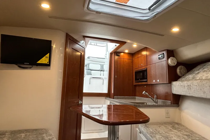 Slide: The Image of 2024 Albemarle 30 Express cabin interior with kitchenette, TV, and seating area. - 14