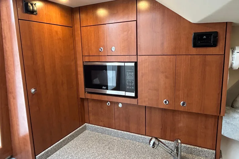 Slide: The Image of 2024 Albemarle 30 Express kitchen with wood cabinetry and built-in microwave. - 16