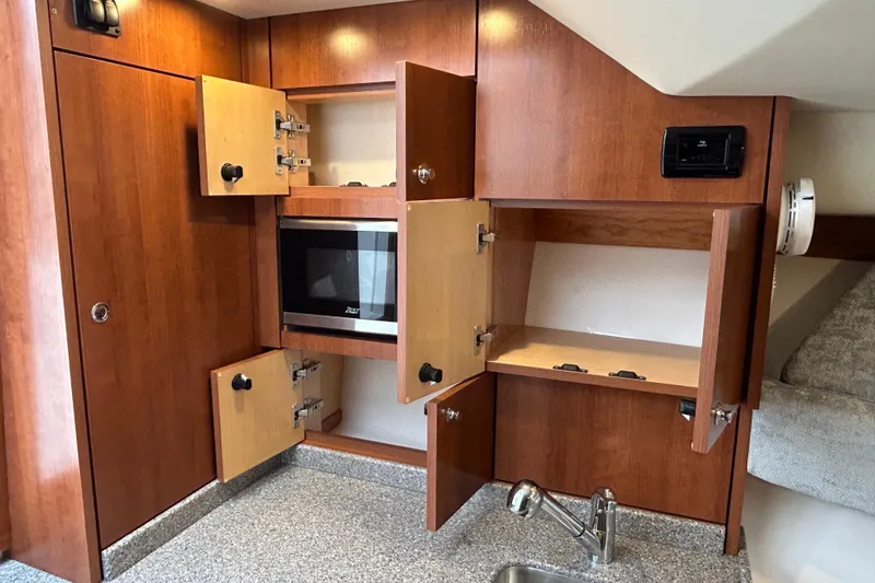 Slide: The Image of 2024 Albemarle 30 Express interior with wooden cabinets and a built-in microwave. - 17