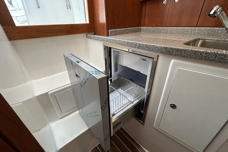 Slide: The Image of 2024 Albemarle 30 Express boat interior with open refrigerator and sleek countertop. - 18