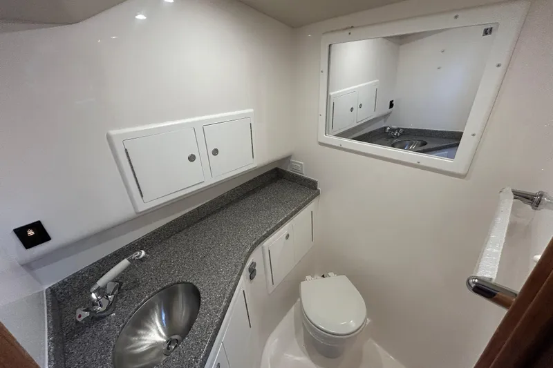Slide: The Image of 2024 Albemarle 30 Express bathroom with sink, toilet, mirror, and storage cabinets. - 19