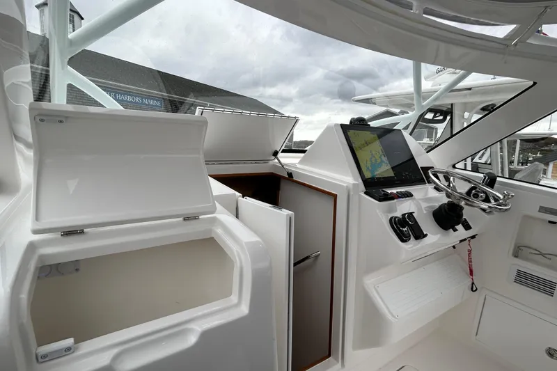 Slide: The Image of 2024 Albemarle 30 Express boat cockpit with navigation system and storage compartments. - 25