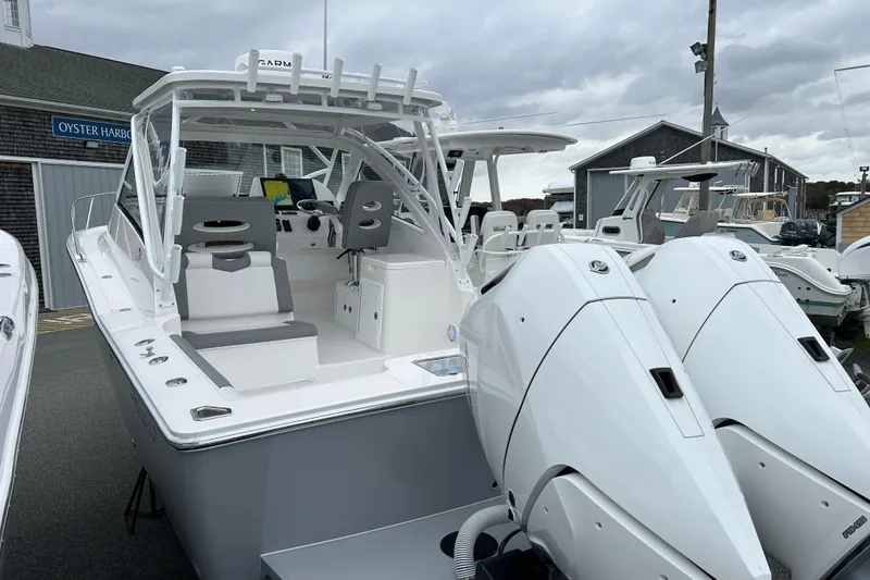 Slide: The Image of 2024 Albemarle 30 Express boat with dual engines, docked at a marina under cloudy skies. - 27