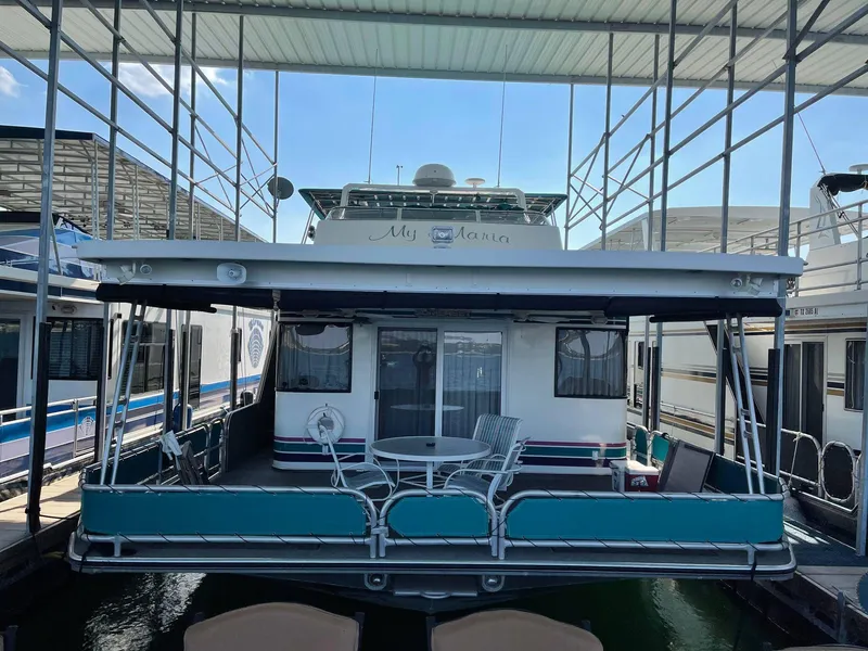 Slide: The Image of 1998 Sumerset 86' by 18' houseboat docked with outdoor seating area. - 14