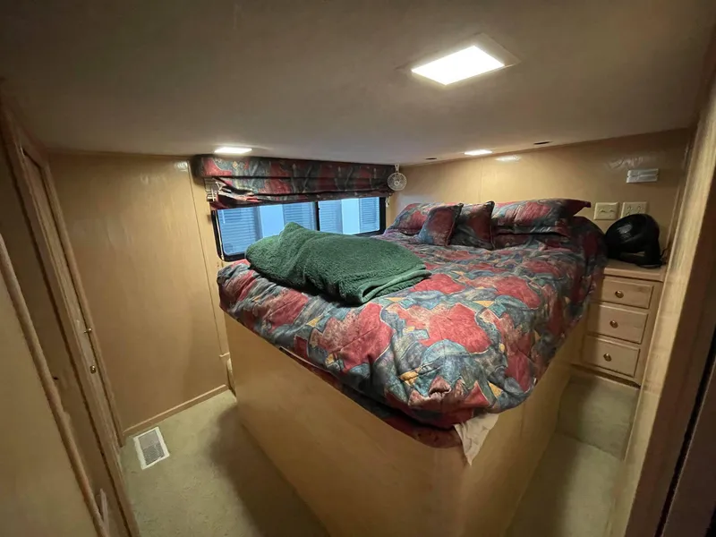 Slide: The Image of Cozy bedroom in a 1998 Sumerset 86' by 18' houseboat with colorful bedding. - 18