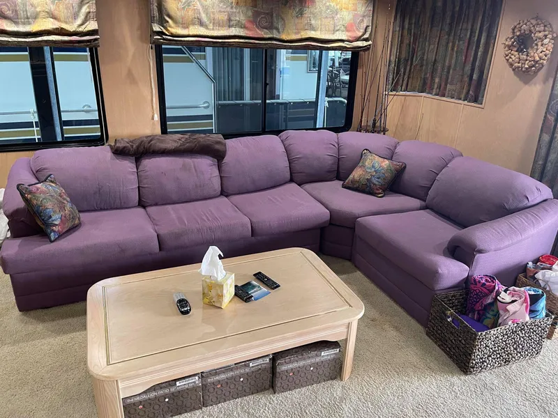 Slide: The Image of 1998 Sumerset 86' by 18' houseboat interior with purple sectional sofa and coffee table. - 6