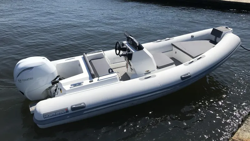 The Image of 2021 Northstar Axis 4.8 boat with Tohatsu engine on calm water. - 1