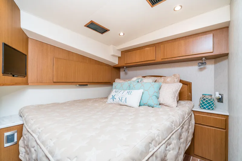 Slide: The Image of Henriques 50 Sportfisherman 2025 bedroom with cozy bed and wooden cabinetry. - 10