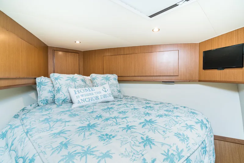Slide: The Image of 2025 Henriques 50 Sportfisherman cabin with cozy bed and nautical-themed decor. - 11