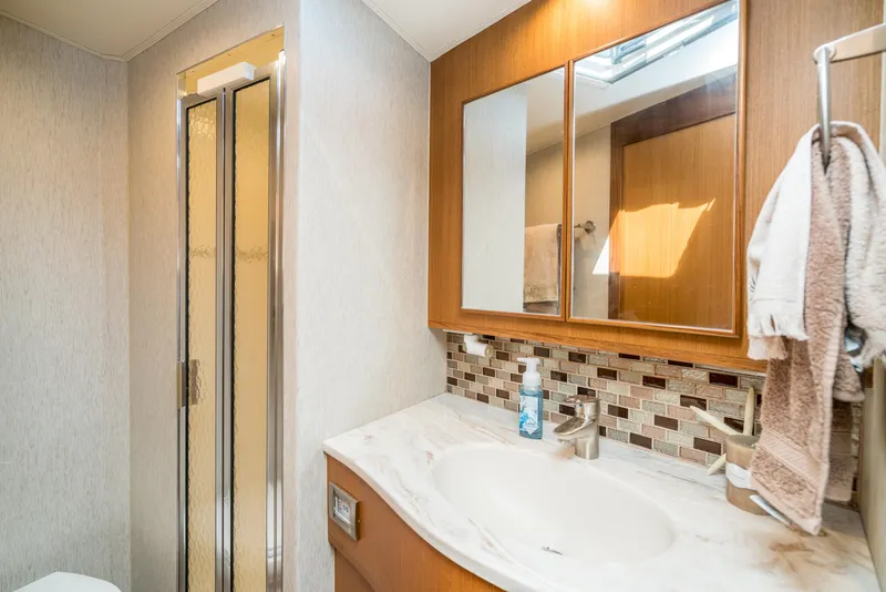 Slide: The Image of 2025 Henriques 50 Sportfisherman bathroom with shower, sink, and mirrored cabinet. - 12