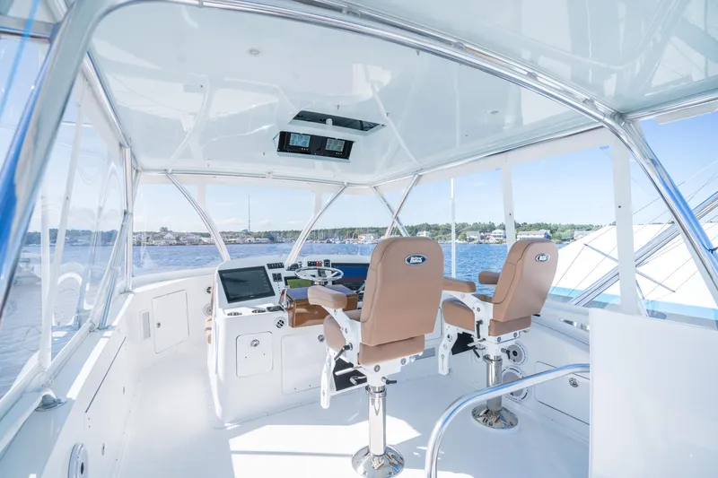 Slide: The Image of 2025 Henriques 50 Sportfisherman helm station with dual captain chairs and navigation equipment. - 14