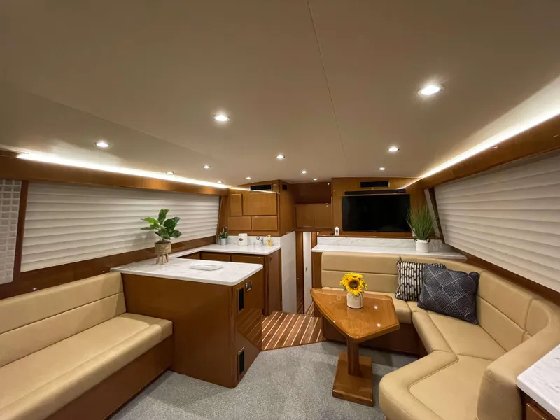 Slide: The Image of 2025 Henriques 50 Sportfisherman interior, modern design with beige seating, wooden accents, and LED lighting. - 25
