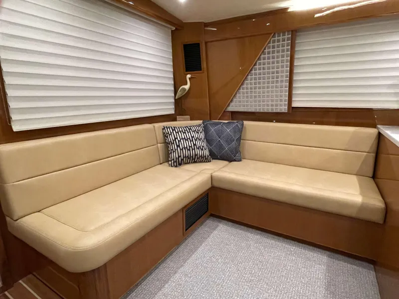 Slide: The Image of 2025 Henriques 50 Sportfisherman interior with beige leather seating and decorative pillows. - 28