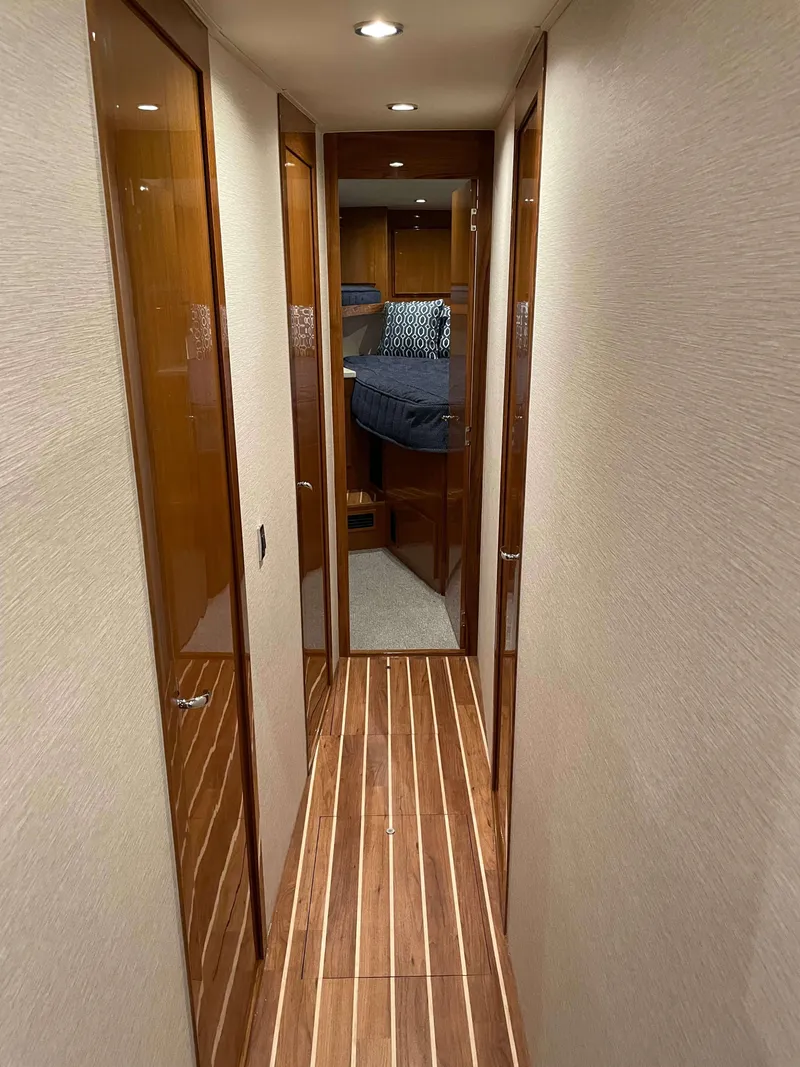 Slide: The Image of Hallway inside 2025 Henriques 50 Sportfisherman yacht with wood flooring and cabin view. - 30