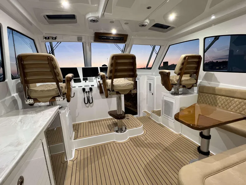 Slide: The Image of 2025 Henriques 42 Express boat interior with helm chairs and seating area. - 10