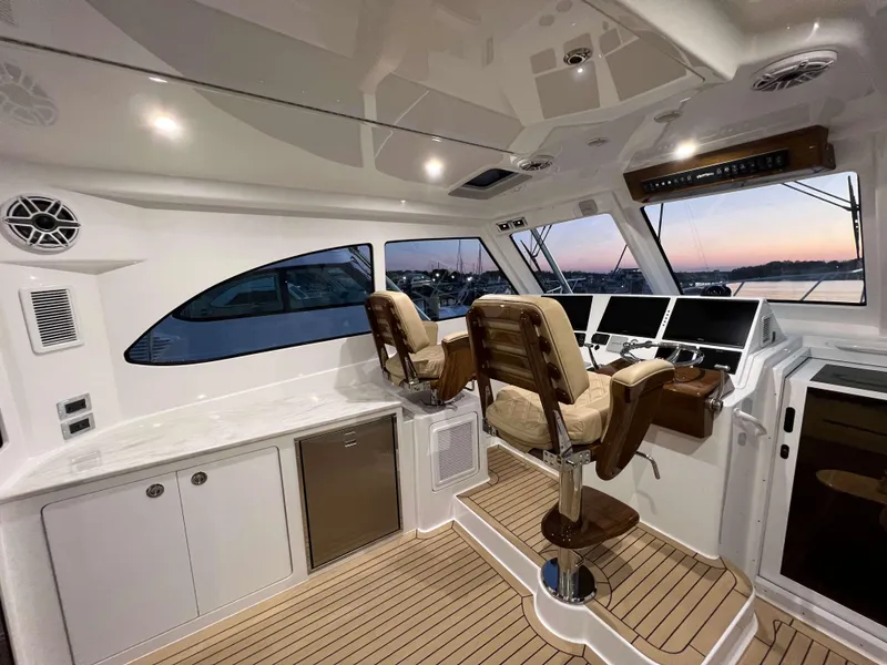 Slide: The Image of 2025 Henriques 42 Express yacht interior with helm station and seating. - 12