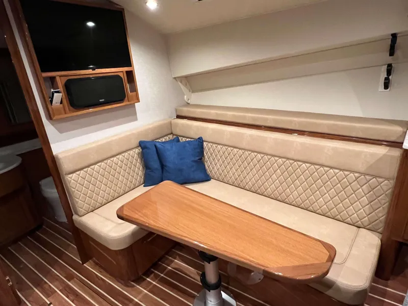 Slide: The Image of Luxurious interior of 2025 Henriques 42 Express yacht with cushioned seating and wooden table. - 18